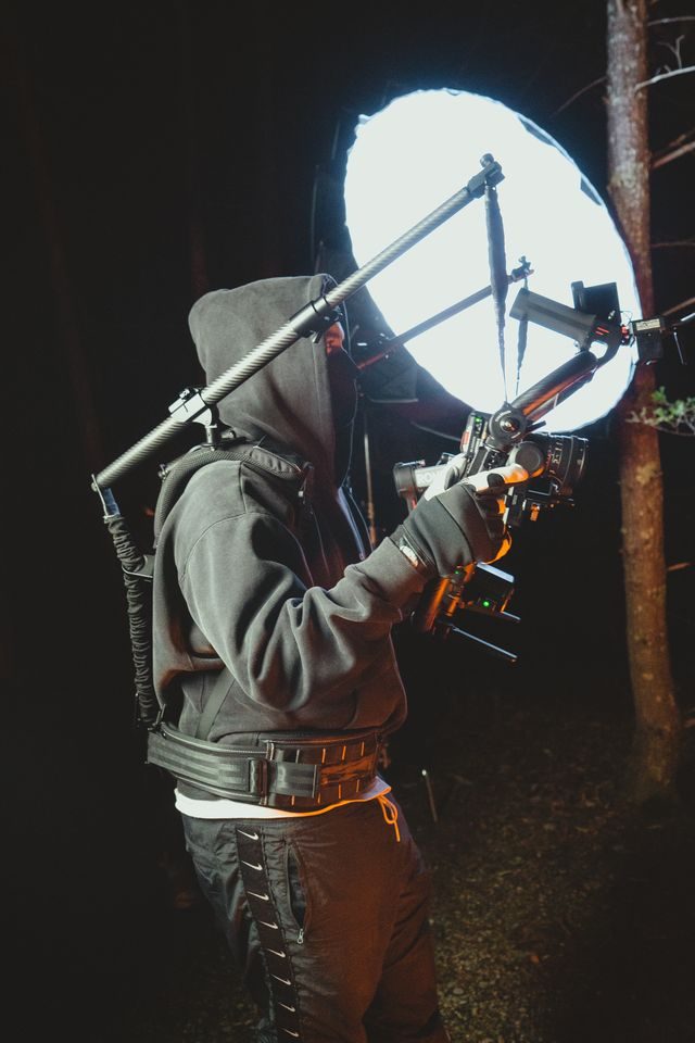 Filmmaker operating a camera rig on a night shoot